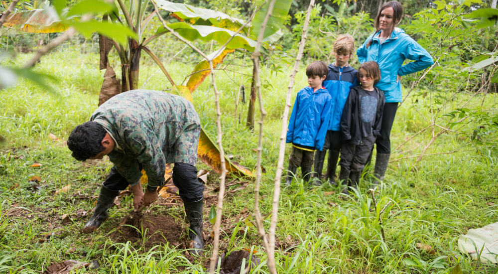 Voyage en famille avec un guide local lors d’un séjour écoresponsable, découvrant des pratiques durables